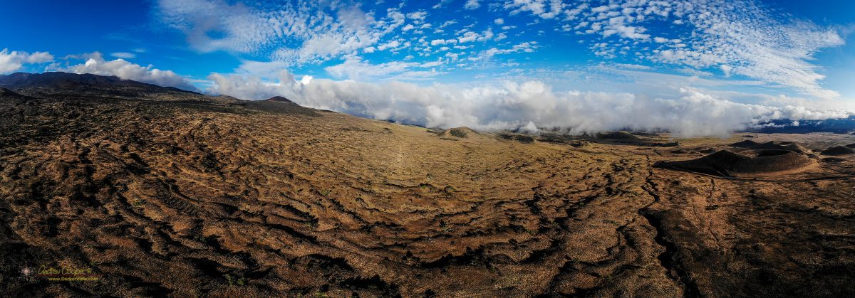 A panorama of the south flank of Mauna Kea showing old lava flows and puʻu