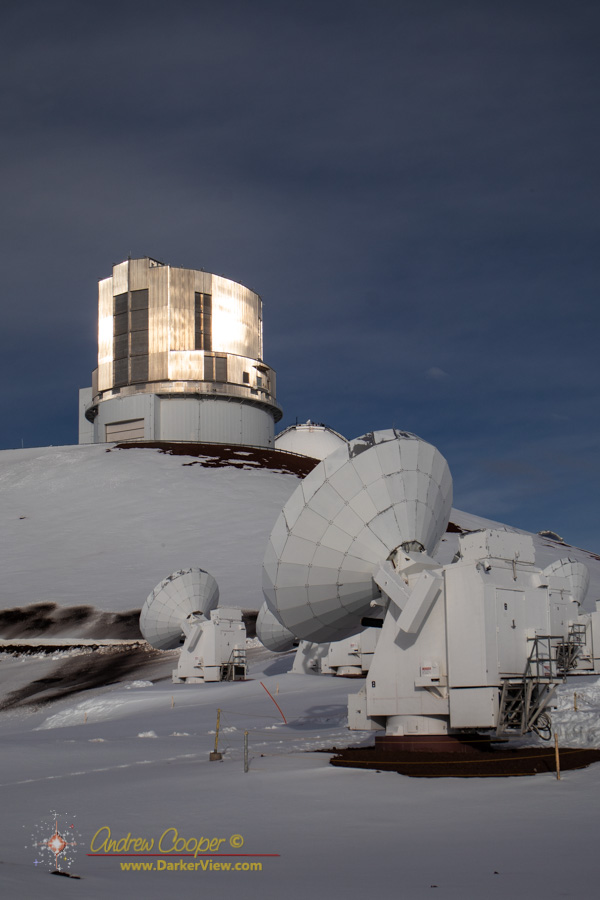 Several of the SMA antenna in front of the Subaru Telescope