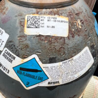 A compressed gas cylinder with inspection dates spanning over a cetury