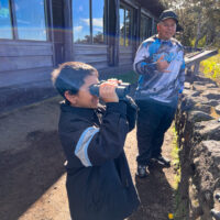 A local boy and his father borrow my binoculars for a better look at the lava