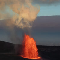 The tall lava fountian of episode 45 in Kilauea Caldera as photographed from the Keanakako'i Overlook with Mauna Loa in the background, on the morning of April 23 , 2026