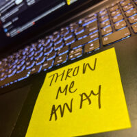 Throw me Away... A bright yellow sticky on a laptop computer